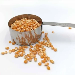 Edelstahl-Messbecher mit 250 ml Füllvolumen, gefüllt mit Popcornmais, auf weißem Hintergrund.